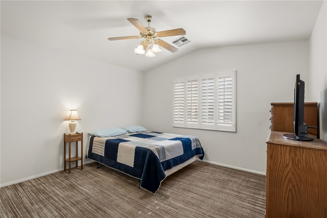 3342 Park Ridge Avenue Bullhead City, AZ 86429 - Photo 16 of 93 This room features a ceiling fan with integrated lighting, a window with white louvered shutters, and vaulted ceilings