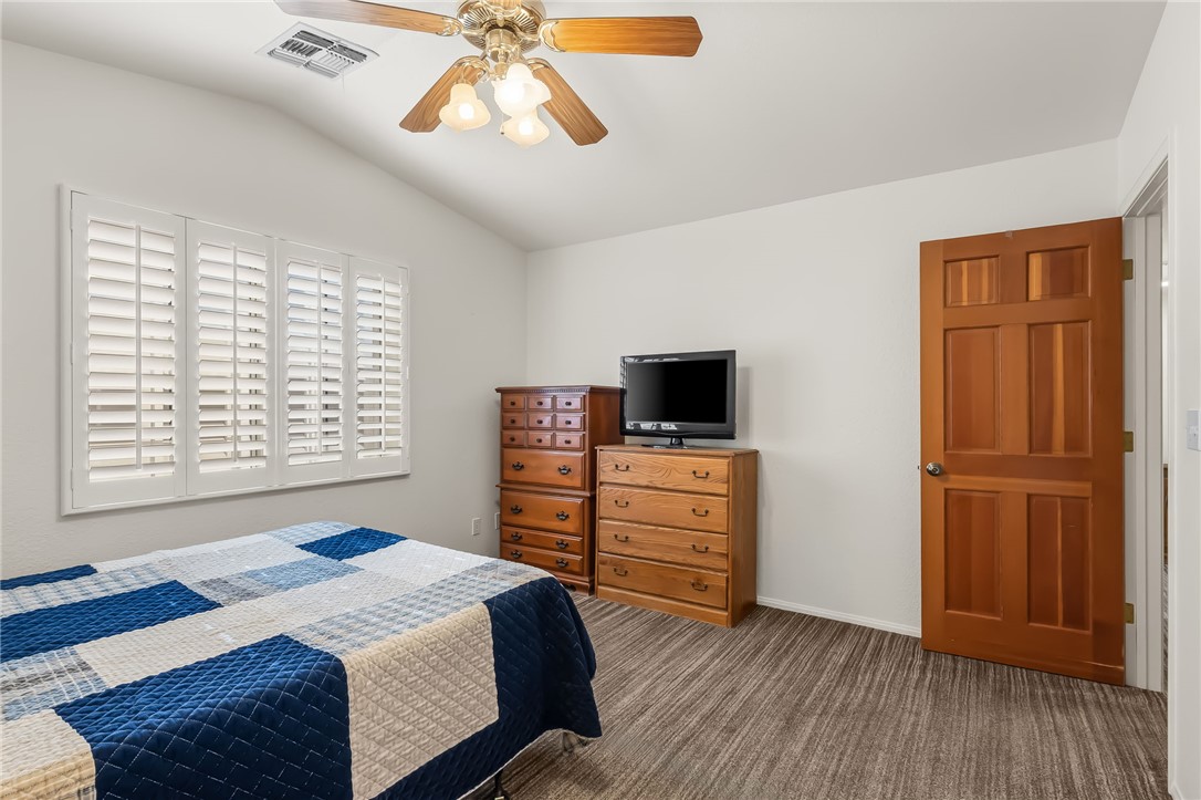 3342 Park Ridge Avenue Bullhead City, AZ 86429 - Photo 17 of 93 This bedroom features white walls, a vaulted ceiling, and wood-paneled flooring