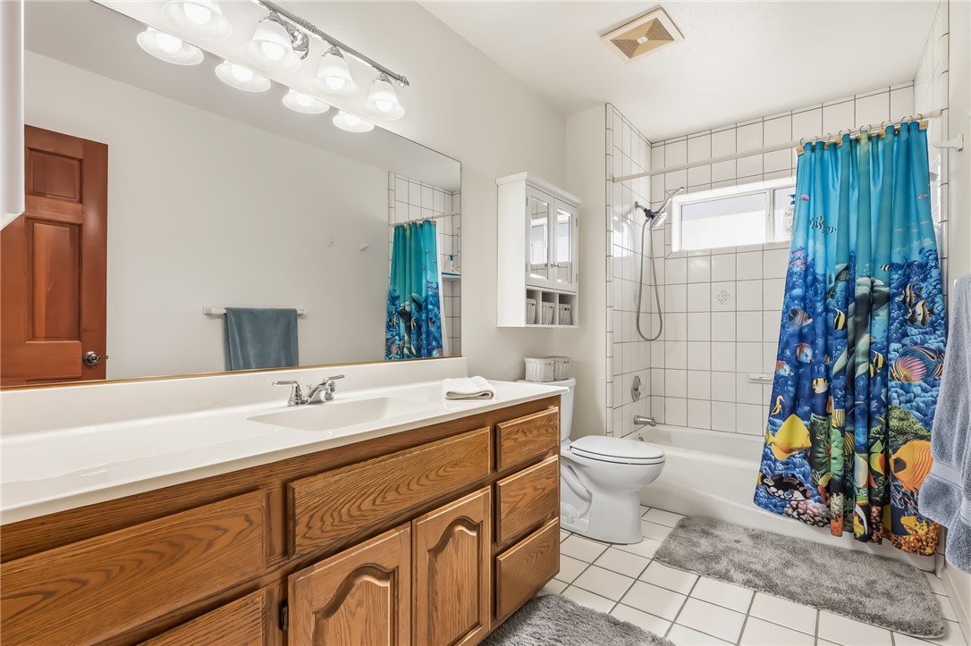 3342 Park Ridge Avenue Bullhead City, AZ 86429 - Photo 18 of 93 The bathroom features a vanity with a white countertop, a mirror with overhead lighting, a toilet, and a shower-over-bath with white tiled walls