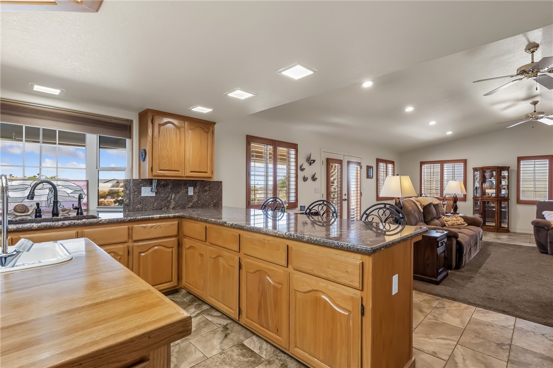 3342 Park Ridge Avenue Bullhead City, AZ 86429 - Photo 24 of 93 The kitchen features natural wood cabinetry, a sink with a dark-toned faucet, and granite countertops