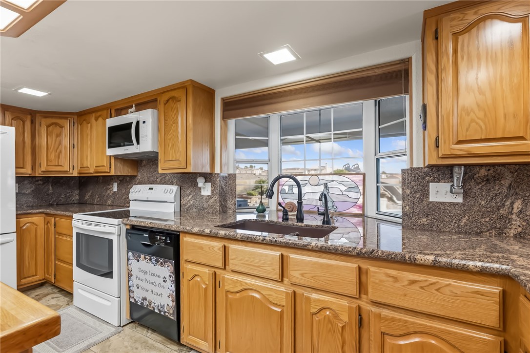 3342 Park Ridge Avenue Bullhead City, AZ 86429 - Photo 27 of 93 The kitchen features wood cabinetry, granite countertops, a built-in microwave, and a double-basin sink