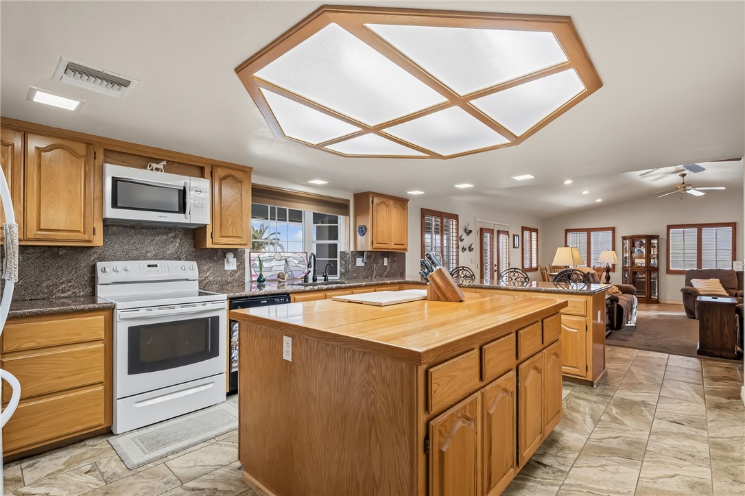 3342 Park Ridge Avenue Bullhead City, AZ 86429 - Photo 29 of 93 The kitchen features wood cabinetry, a central island with a wood countertop, and a white oven/range with an overhead microwave