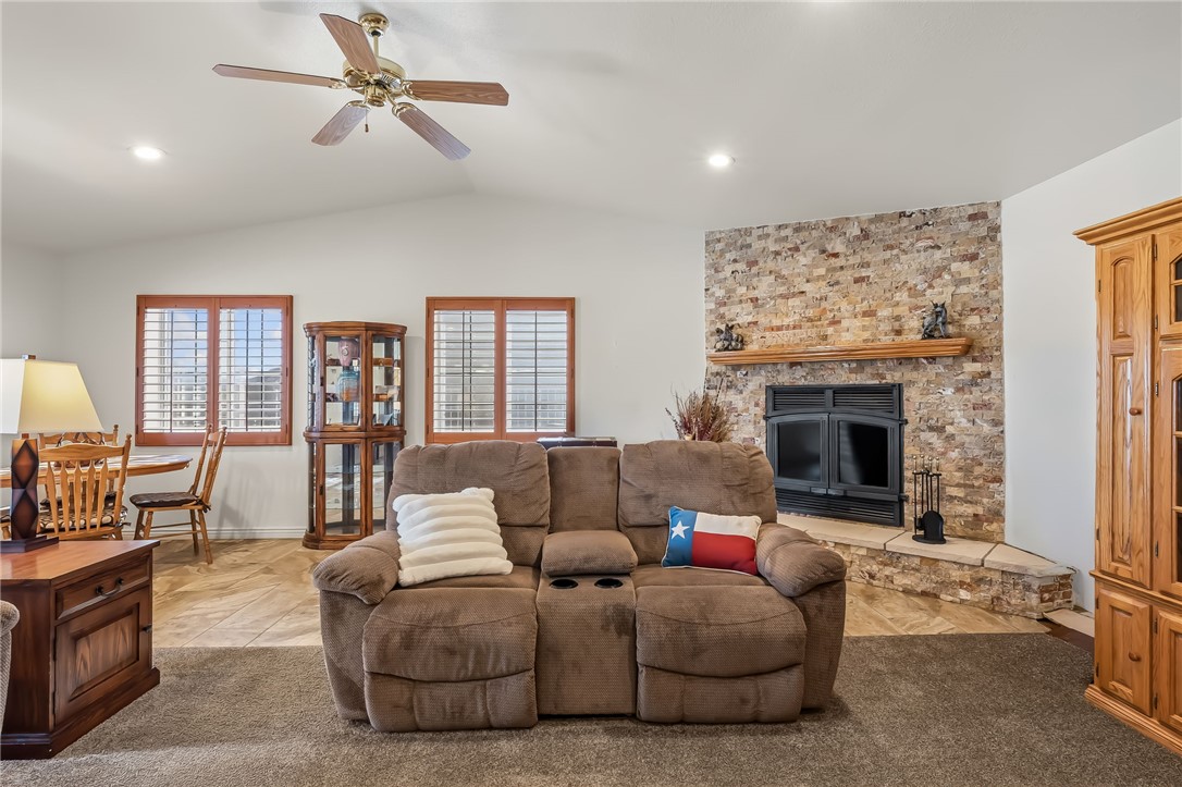3342 Park Ridge Avenue Bullhead City, AZ 86429 - Photo 38 of 93 Living room featuring vaulted ceilings, a ceiling fan, recessed lighting, and a stone-faced fireplace with a wooden mantel