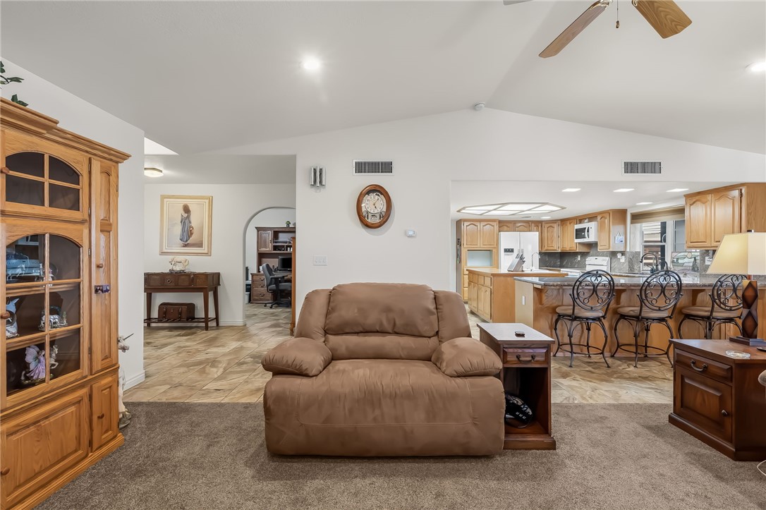 3342 Park Ridge Avenue Bullhead City, AZ 86429 - Photo 40 of 93 The property features a spacious living area with vaulted ceilings and recessed lighting, opening into a kitchen with light wood cabinetry and an island with bar seating