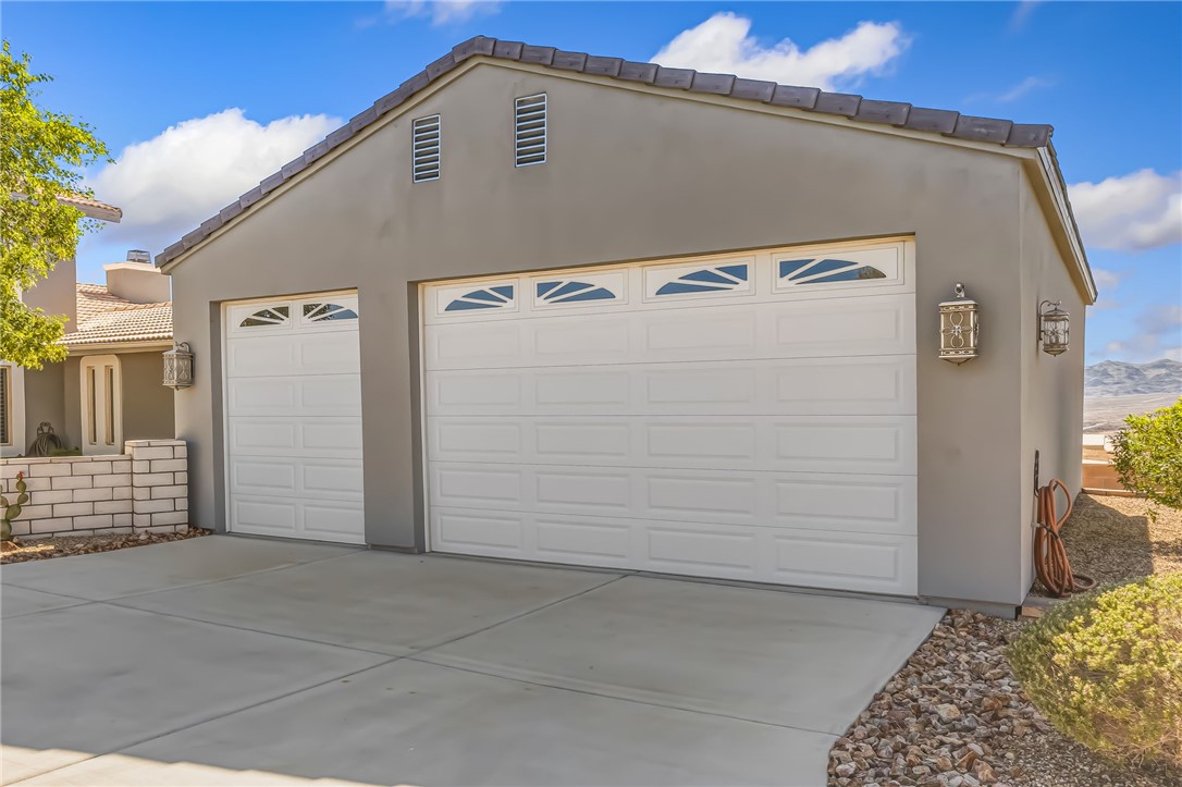 3342 Park Ridge Avenue Bullhead City, AZ 86429 - Photo 4 of 93 The property features a three-car boat deep detached garage with white paneled doors, each with upper window inserts