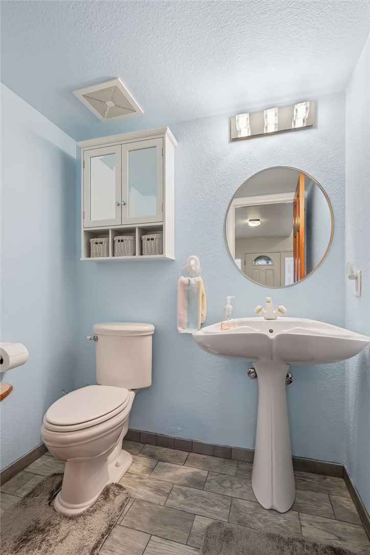 3342 Park Ridge Avenue Bullhead City, AZ 86429 - Photo 41 of 93 Bathroom featuring a white pedestal sink, a toilet, and a wall-mounted cabinet with mirrored doors