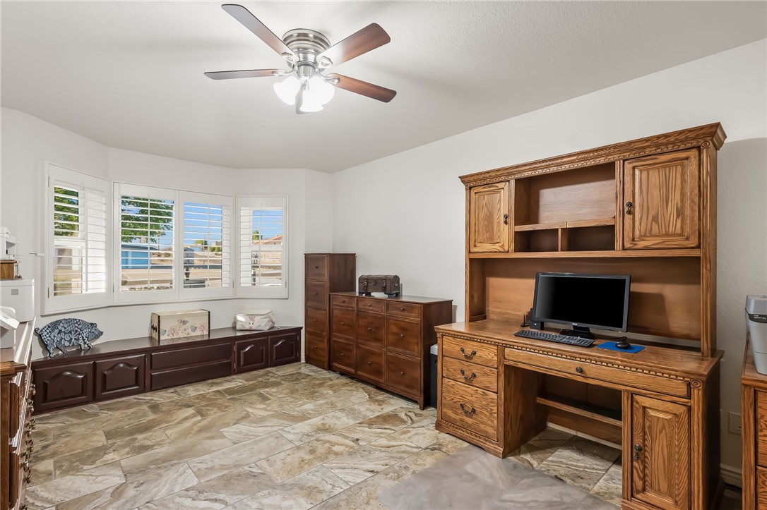 3342 Park Ridge Avenue Bullhead City, AZ 86429 - Photo 44 of 93 This room features tile flooring, a bay window with white plantation shutters, and a ceiling fan with integrated lighting