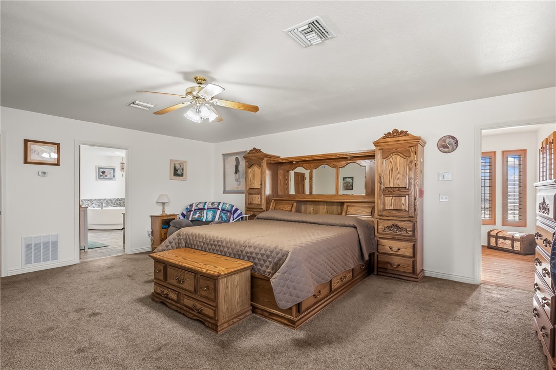 3342 Park Ridge Avenue Bullhead City, AZ 86429 - Photo 49 of 93 The room features a ceiling fan, carpeted flooring, and a doorway leading to a separate area with a bathtub