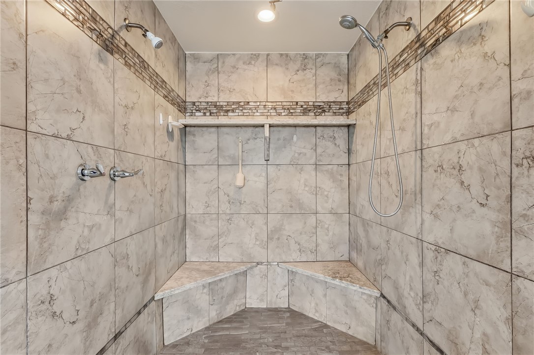 3342 Park Ridge Avenue Bullhead City, AZ 86429 - Photo 57 of 93 The shower features tiled walls with decorative accent banding, dual shower heads, and built-in corner benches