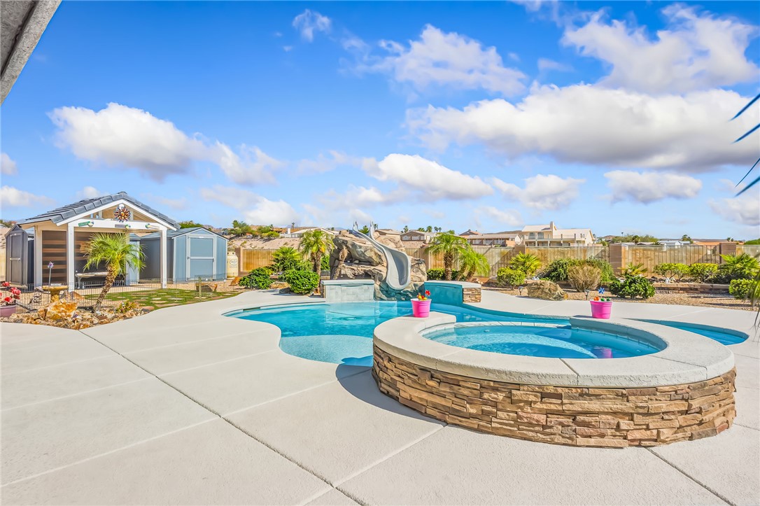 3342 Park Ridge Avenue Bullhead City, AZ 86429 - Photo 61 of 93 The property includes an outdoor pool area with a built-in spa, a water slide, and a rock waterfall feature