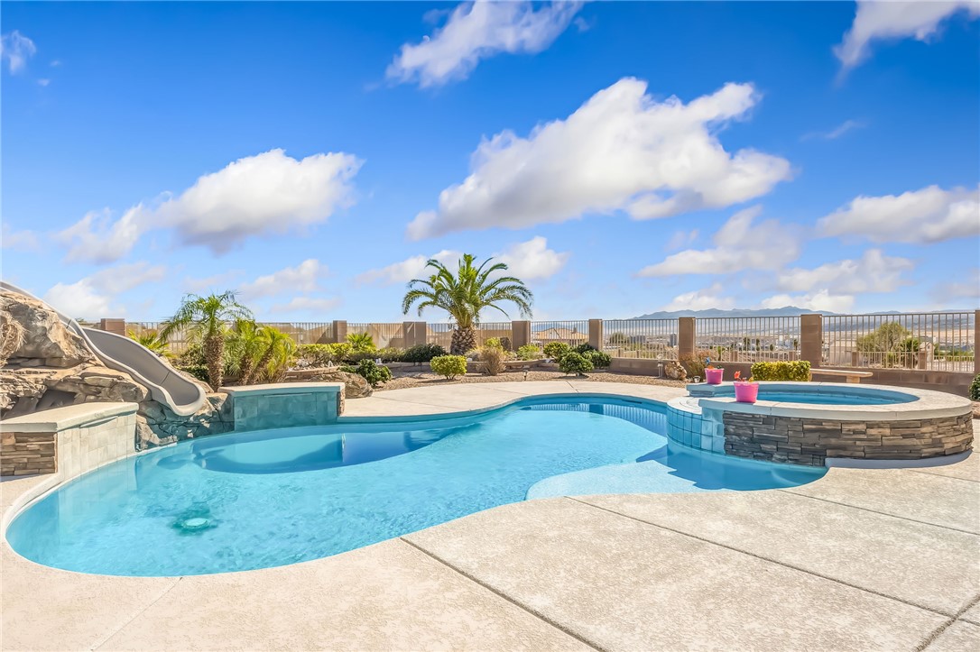 3342 Park Ridge Avenue Bullhead City, AZ 86429 - Photo 62 of 93 The property features a large outdoor pool with a built-in slide, surrounded by a concrete patio
