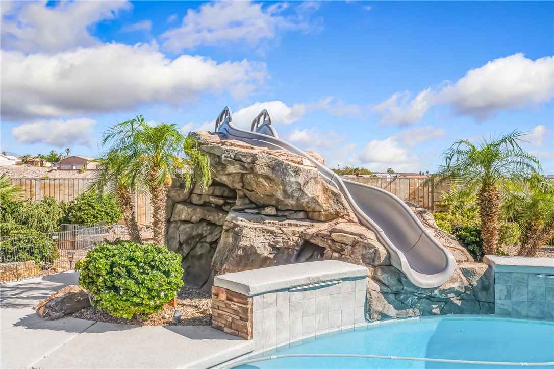 3342 Park Ridge Avenue Bullhead City, AZ 86429 - Photo 63 of 93 The property features a swimming pool with a rock formation and an integrated slide