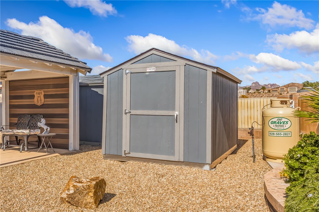 3342 Park Ridge Avenue Bullhead City, AZ 86429 - Photo 65 of 93 The property features a durable shed with a gray exterior and light trim, situated on a bed of gravel