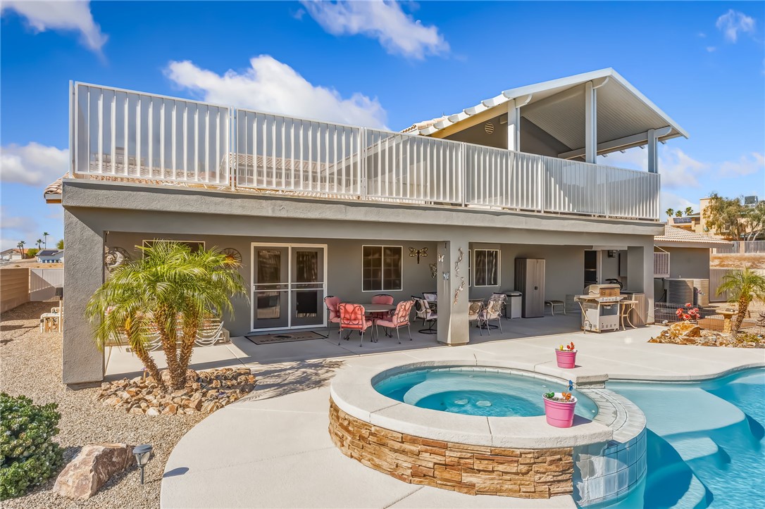 3342 Park Ridge Avenue Bullhead City, AZ 86429 - Photo 69 of 93 The property features a spacious outdoor area with a swimming pool, a hot tub with stone detailing, and a covered patio