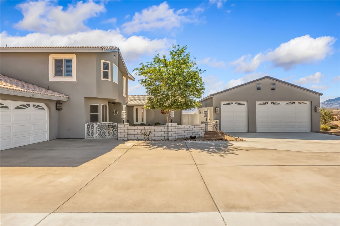 3342 Park Ridge Avenue Bullhead City, AZ 86429 - Photo 7 of 93 The property features a multi-car garage, a paved driveway, and a front entrance with a decorative gate
