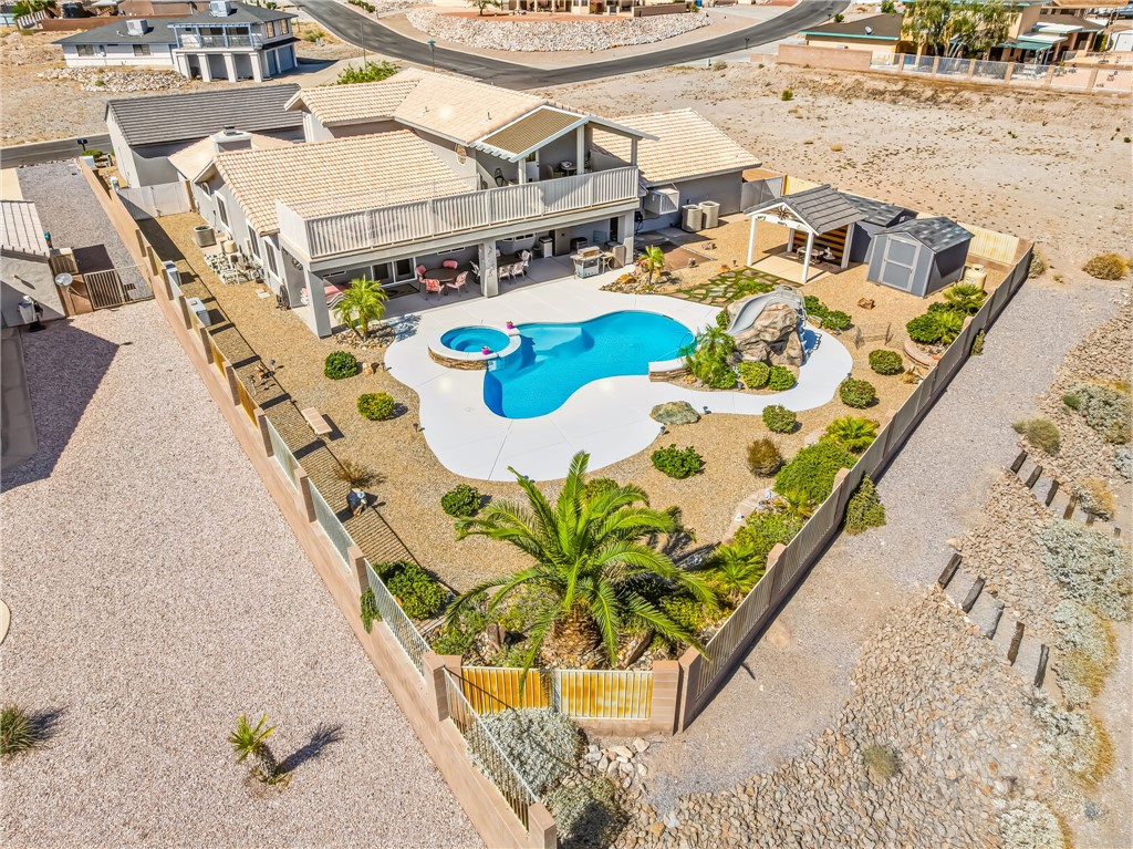 3342 Park Ridge Avenue Bullhead City, AZ 86429 - Photo 82 of 93 The property features a private swimming pool with an integrated spa and slide, surrounded by a landscaped yard with mature plants and shrubs