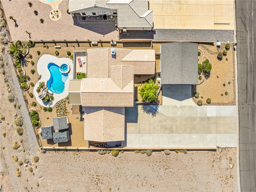 3342 Park Ridge Avenue Bullhead City, AZ 86429 - Photo 85 of 93 Aerial view of the property showing a private pool with an integrated spa, a paved driveway, and desert-style landscaping