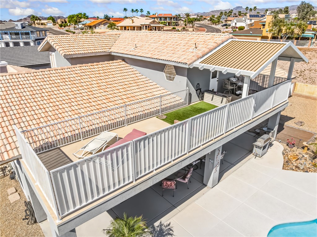 3342 Park Ridge Avenue Bullhead City, AZ 86429 - Photo 87 of 93 The property features a large tiled roof, a spacious balcony with white railings, and an outdoor living area with a covered patio
