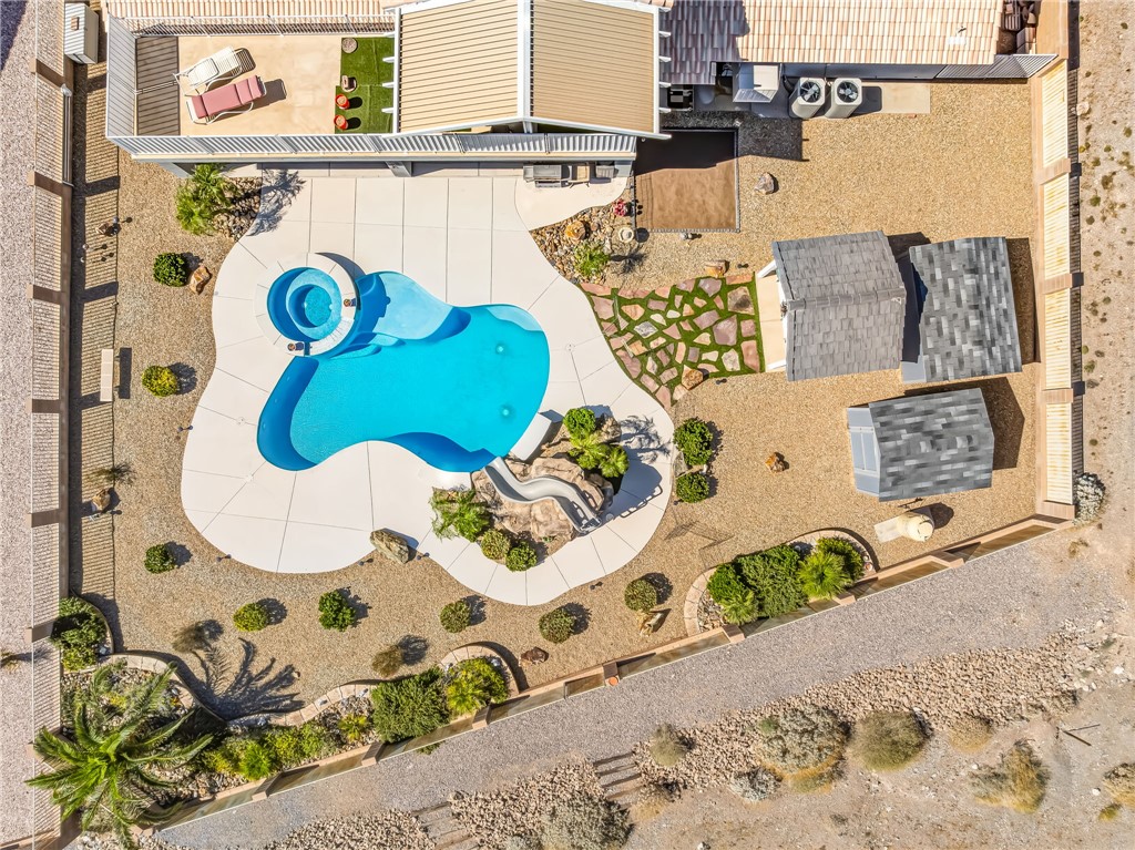3342 Park Ridge Avenue Bullhead City, AZ 86429 - Photo 88 of 93 The property features an outdoor swimming pool with an integrated spa, a paved pool deck, and landscaped areas with various plantings