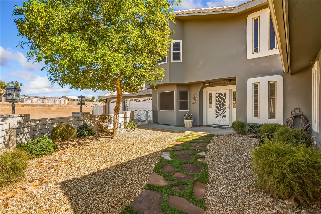 3342 Park Ridge Avenue Bullhead City, AZ 86429 - Photo 9 of 93 The property features a landscaped front yard with gravel, a stone path, and a mature tree