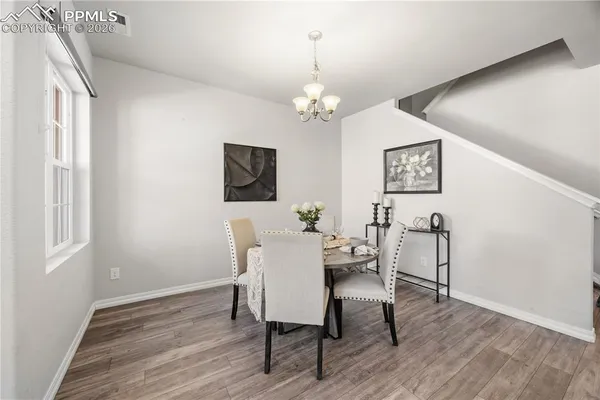 a view of a dining room with furniture a chandelier and wooden floor