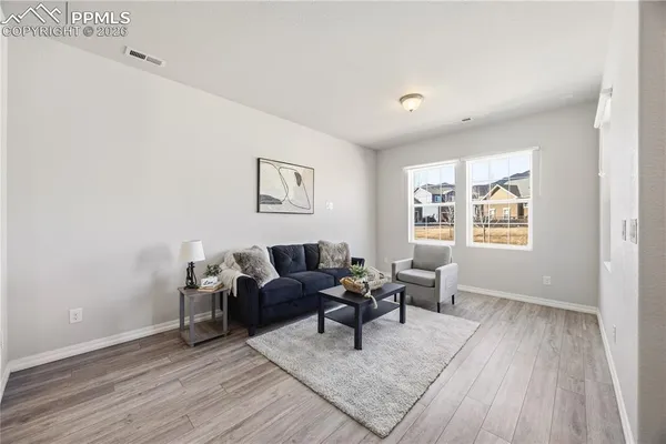 a living room with furniture and a wooden floor