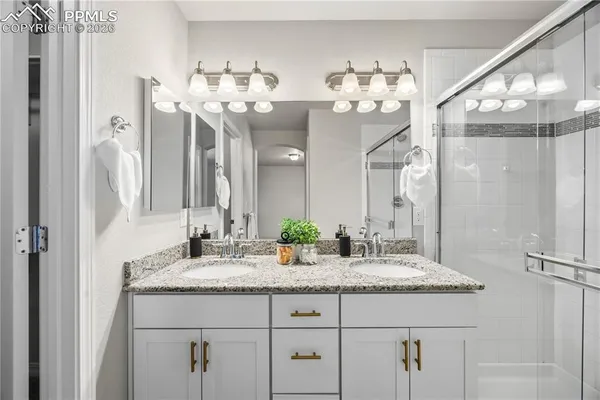 a bathroom with a granite countertop sink a large mirror and a chandelier