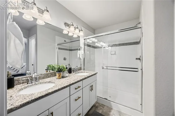 a bathroom with a granite countertop sink mirror and a shower