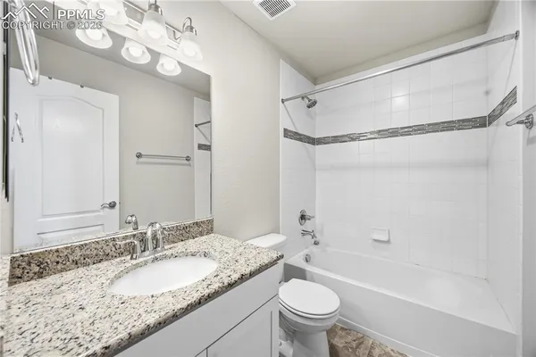 a bathroom with a granite countertop sink mirror toilet and bathtub