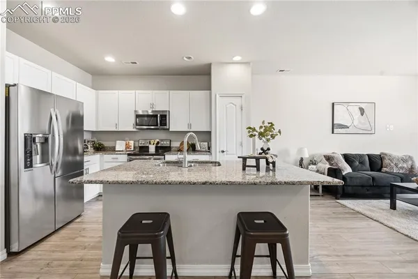a kitchen with stainless steel appliances granite countertop a refrigerator and a stove top oven
