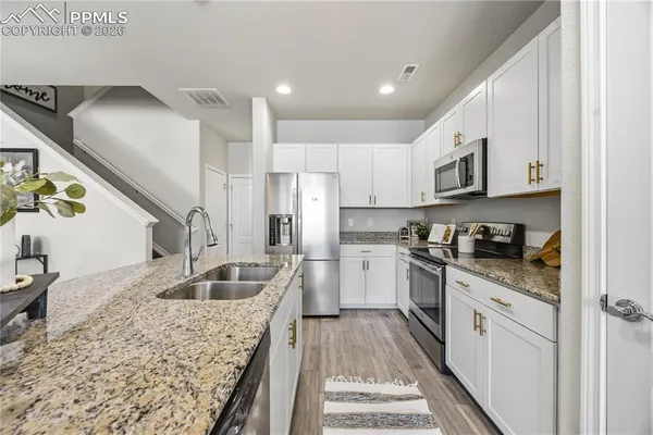a kitchen with stainless steel appliances granite countertop a sink stove and refrigerator