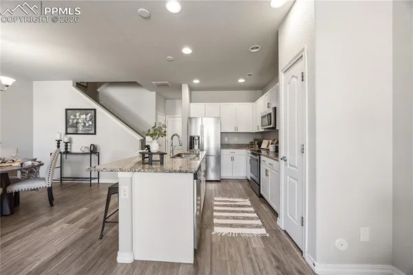 a kitchen with stainless steel appliances kitchen island sink refrigerator and cabinets