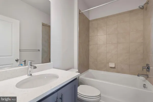 a bathroom with a granite countertop sink toilet and bathtub