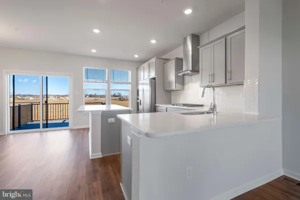 a open kitchen with white cabinets and wooden floor