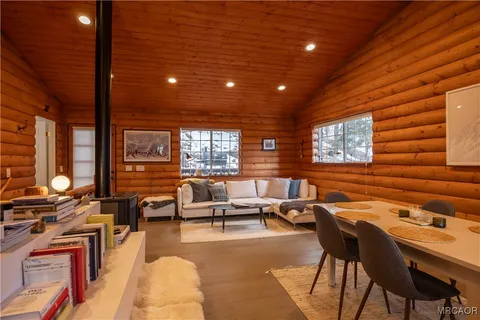 a kitchen with stainless steel appliances kitchen island granite countertop a table chairs in it and wooden floors