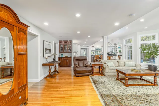 a dining room with wooden floor and large windows
