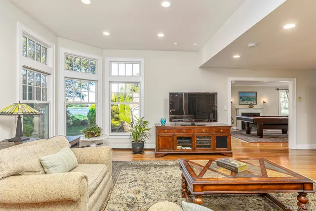 a kitchen with stainless steel appliances granite countertop a stove top oven a sink dishwasher and couches with wooden floor