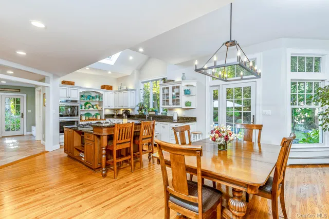 a kitchen with white cabinets and window
