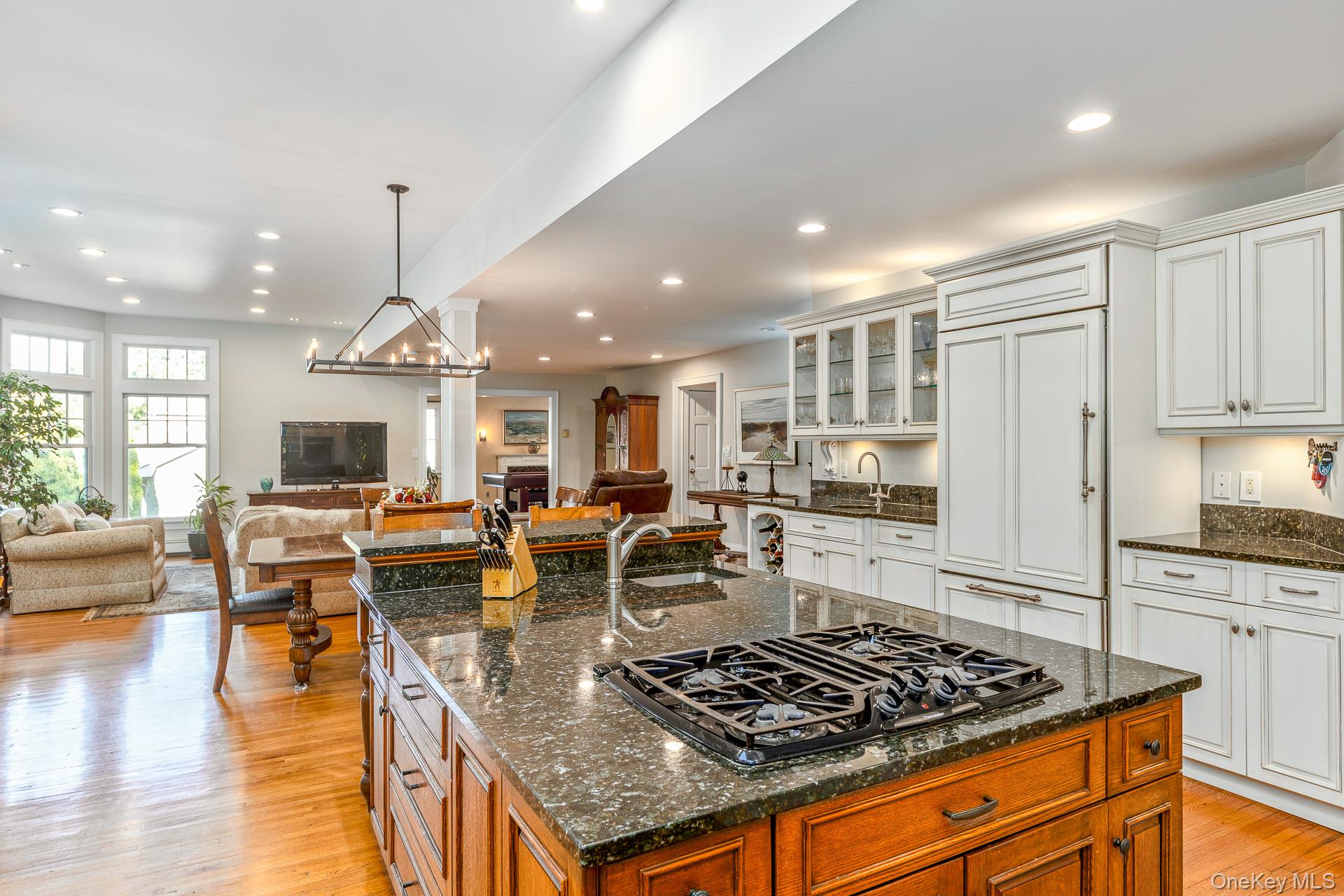 7 Shipyard Lane Setauket, NY 11733 - Photo 16 of 32 a kitchen with stainless steel appliances granite countertop a stove top oven a sink dishwasher and couches with wooden floor