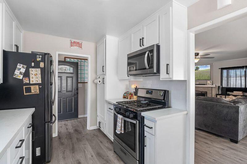 1833 Jenner Street Lancaster, CA 93534 - Photo 13 of 31 a kitchen with stainless steel appliances a stove a microwave and a refrigerator