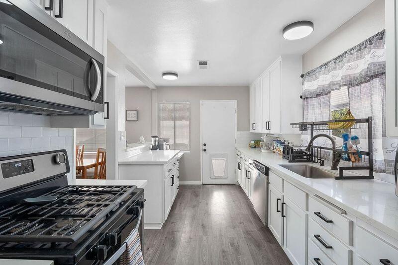 1833 Jenner Street Lancaster, CA 93534 - Photo 10 of 31 a kitchen with stainless steel appliances a stove sink microwave and cabinets