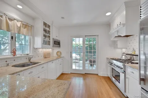 a kitchen with granite countertop a sink stove and cabinets