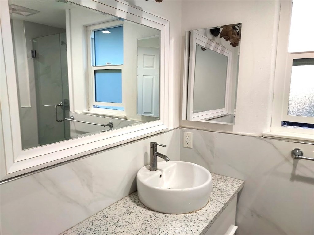 8803 Hummingbird Avenue Fountain Valley, CA 92708 - Photo 26 of 43 a bathroom with a granite countertop sink and a mirror