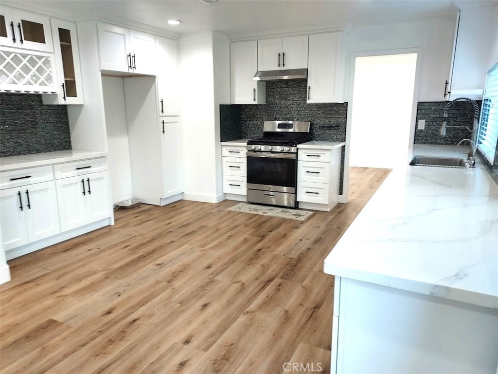 8803 Hummingbird Avenue Fountain Valley, CA 92708 - Photo 28 of 43 a kitchen with stainless steel appliances granite countertop a stove top oven a sink and a refrigerator