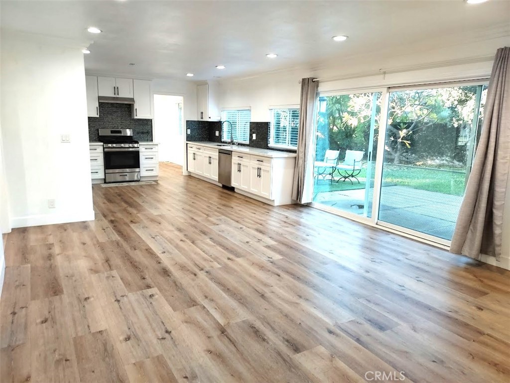 8803 Hummingbird Avenue Fountain Valley, CA 92708 - Photo 32 of 43 an open kitchen with kitchen island and a stove top oven