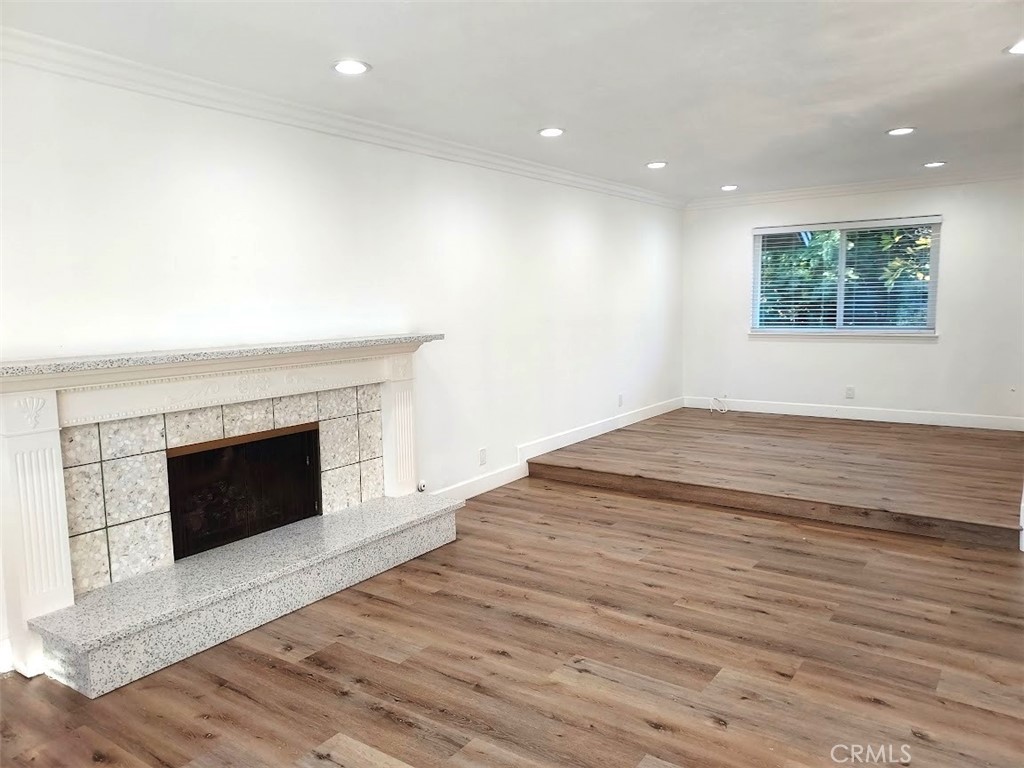 8803 Hummingbird Avenue Fountain Valley, CA 92708 - Photo 9 of 43 an empty room with wooden floor and fireplace
