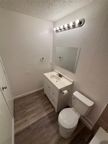 a white toilet sitting next to a bathroom sink and vanity