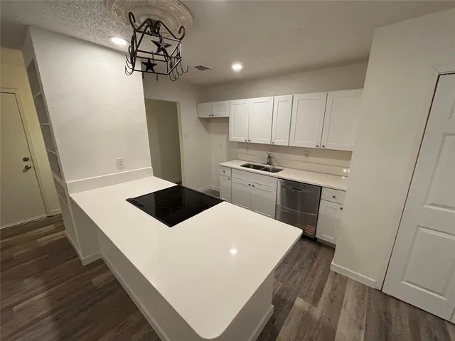 a room with a chandelier and wooden floor