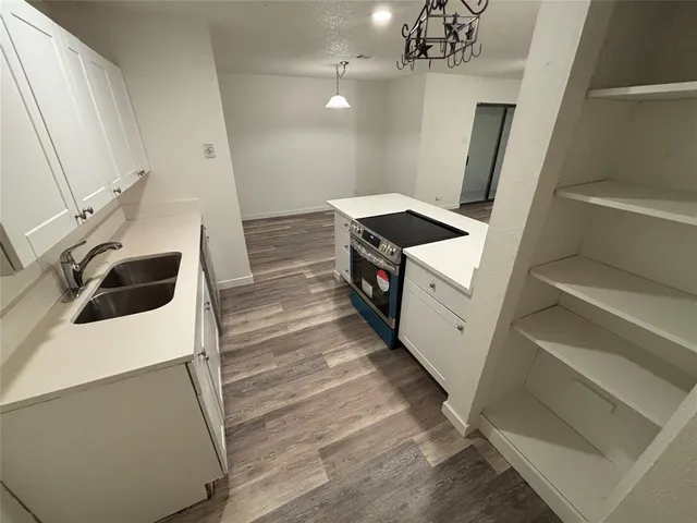 a kitchen with a stove and white cabinets