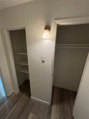 a view of walk in closet with wooden floor